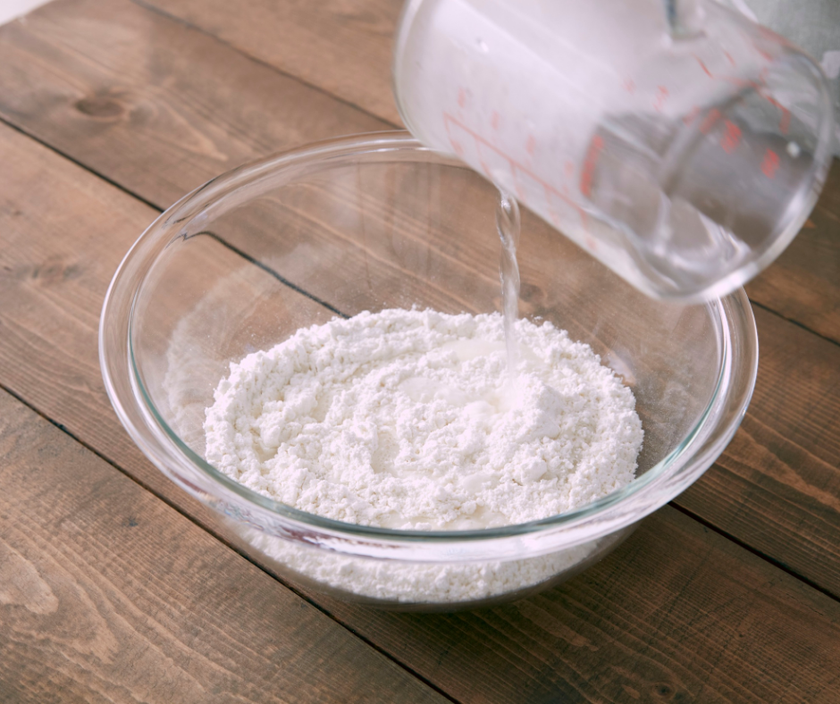 Trộn baking soda với giấm trong tô để tạo hỗn hợp làm sạch ron gạch bị đen mốc.