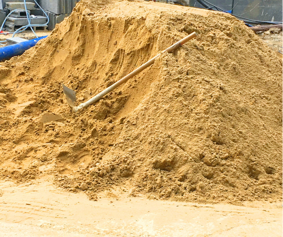 Đống cát xây dựng vàng tại công trình cùng với xẻng xúc.