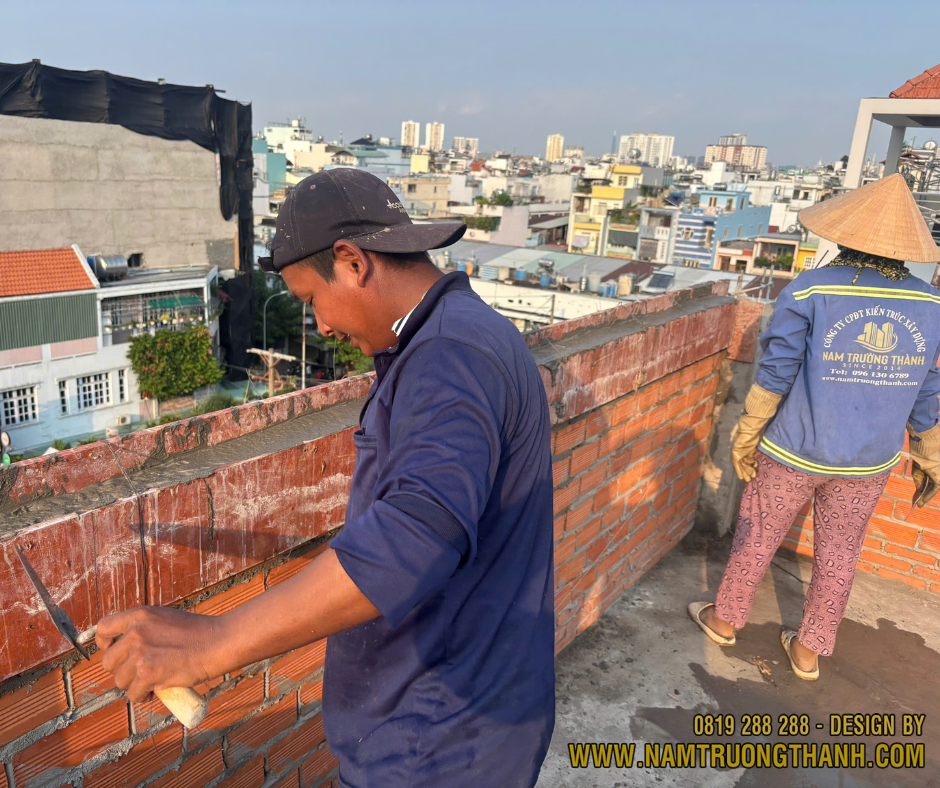 Thợ thi công xây tường bao trên sân thượng chuẩn bị chống thấm.