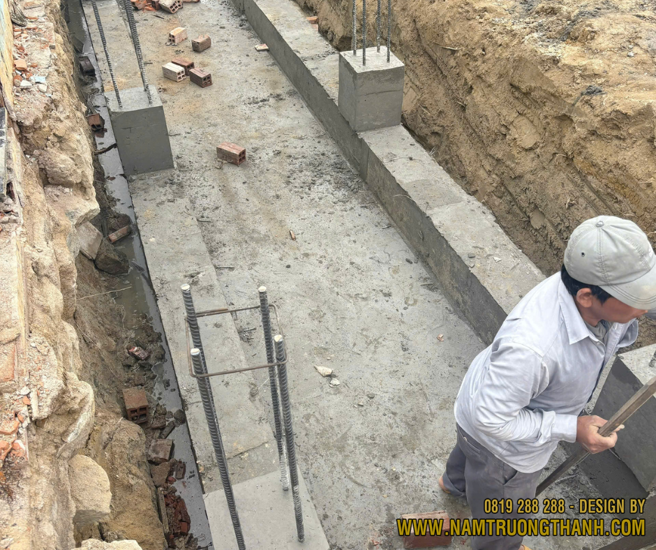 Kỹ thuật viên kiểm tra nghiệm thu phần bê tông hố móng nhà phố.