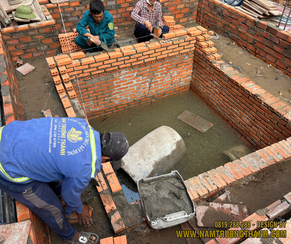 Thợ xây dựng đang thi công hầm tự hoại và hệ thống thoát nước ngầm.