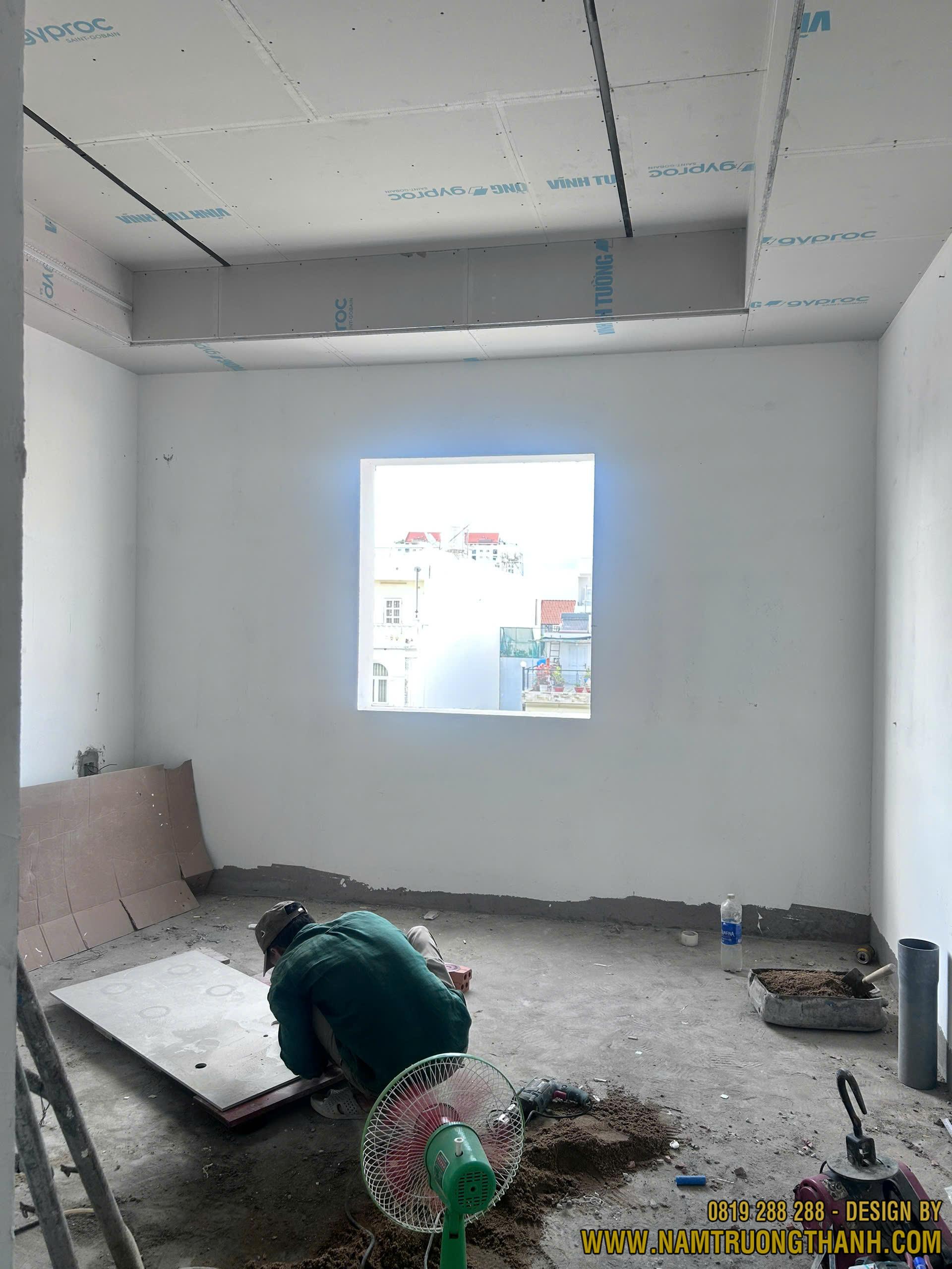 Thợ thi công bắn vít trần thạch cao phòng ngủ thô.