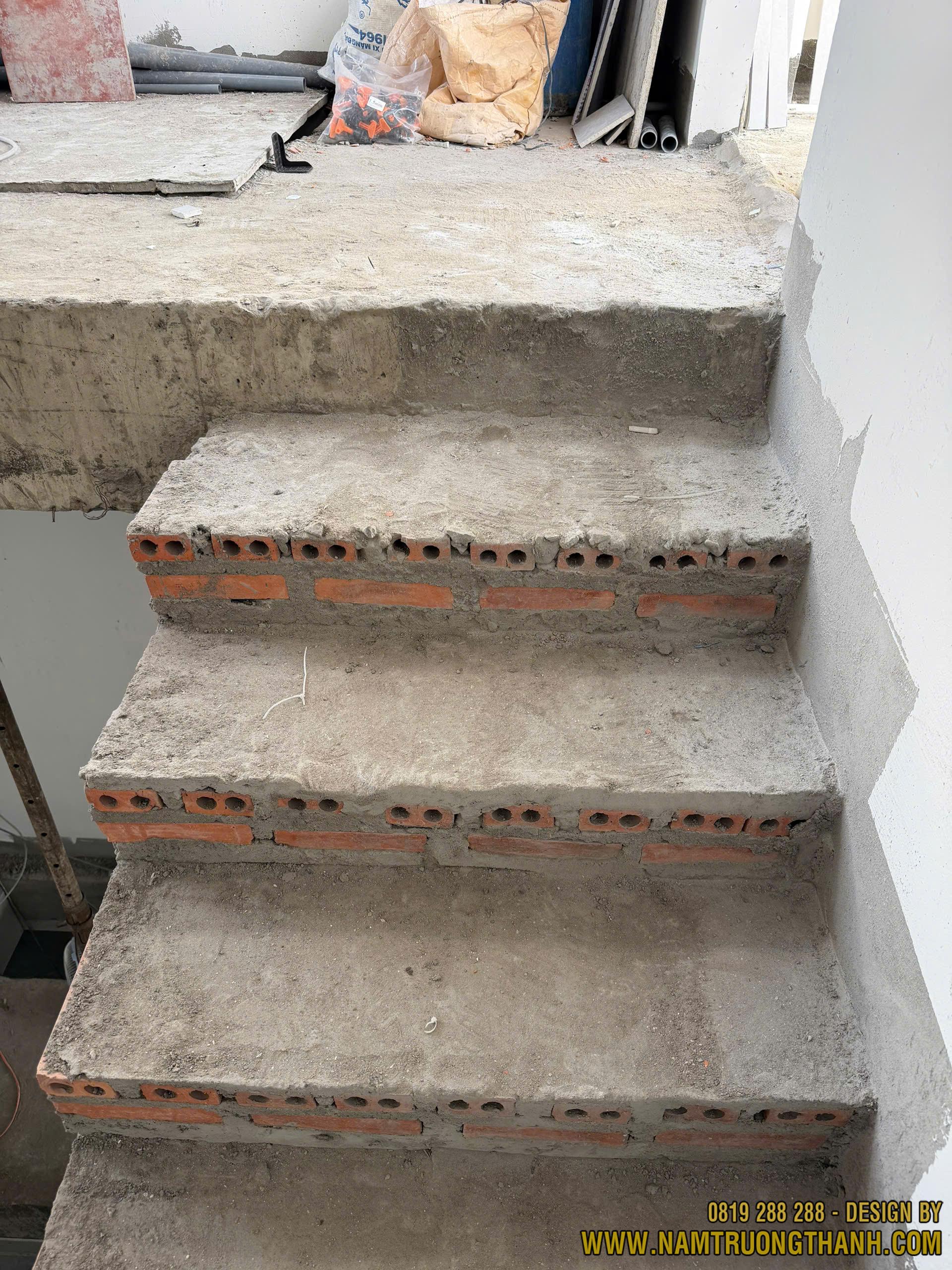 Các bậc cầu thang xây gạch thô chưa đều cốt cao độ tại công trường.
