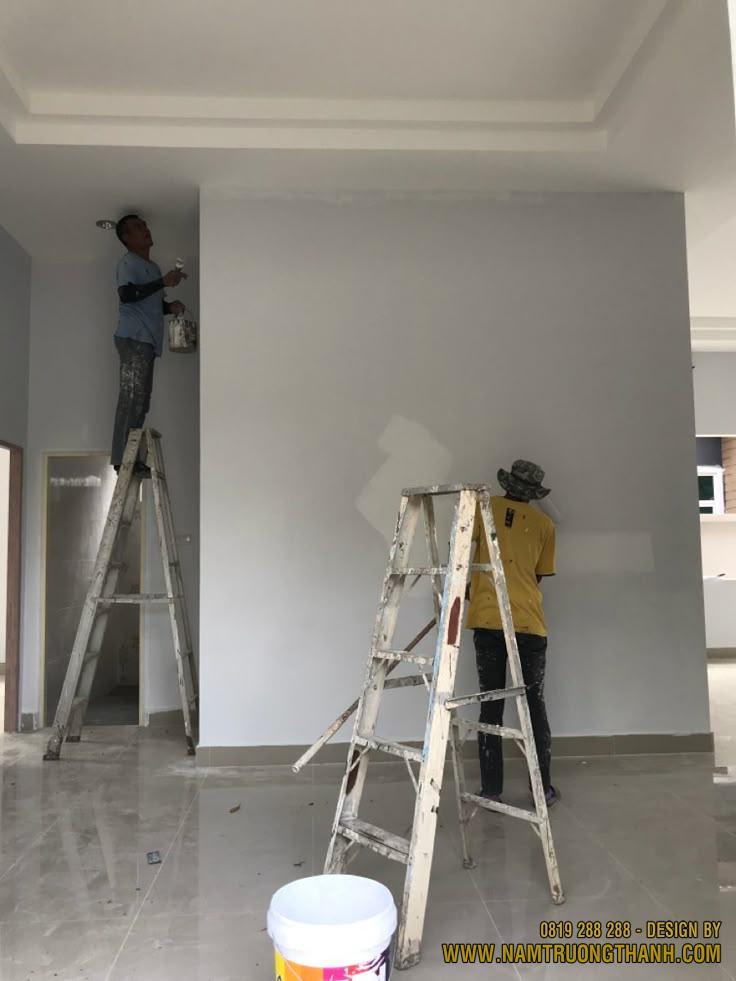 Đội ngũ thợ sơn sử dụng giáo thang thi công sơn phủ nội thất cho không gian phòng khách.